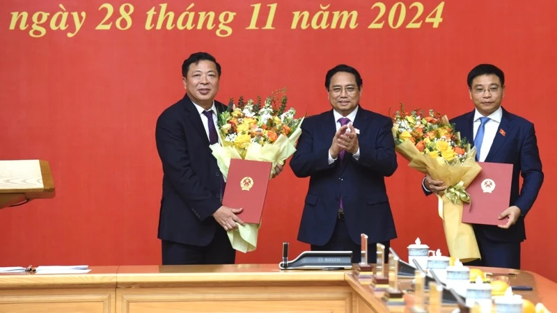 Thủ tướng Phạm Minh Chính tặng hoa chúc mừng Bộ trưởng Tài chính Nguyễn Văn Thắng và Bộ trưởng Giao thông vận tải Trần Hồng Minh. (Ảnh: Trần Hải)