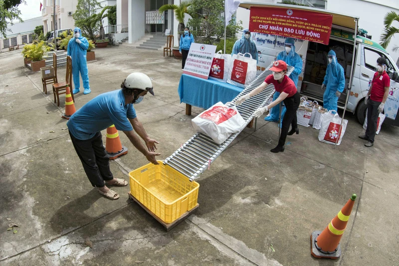 Các cán bộ Hội Chữ thập đỏ hỗ trợ người dân bị ảnh hưởng bởi dịch Covid-19.