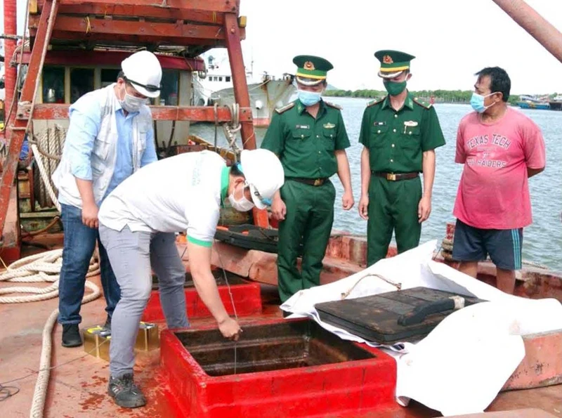 Lực lượng chức năng kiểm tra tàu cá TG90187TS vận chuyển dầu do không có hóa đơn chứng từ theo quy định. (Ảnh NINH NHÂM)