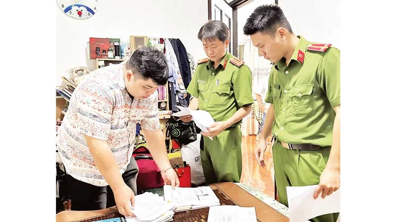 Cơ quan chức năng làm việc với một đối tượng cho vay nặng lãi. (Ảnh CTV)