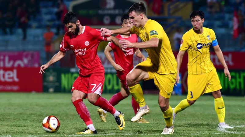 Pha bóng giữa cầu thủ đội Viettel FC (áo đỏ) và đội Sông Lam Nghệ An. (Ảnh TRẦN HẢI)