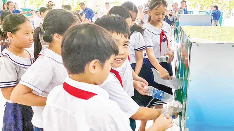 Các em học sinh phân loại rác trước khi bỏ vào xe.