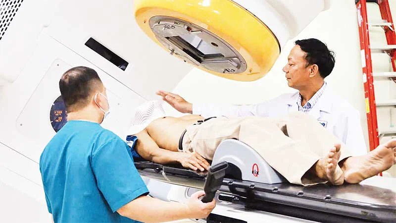 Bác sĩ kiểm tra bệnh nhân trước khi xạ trị lần đầu.