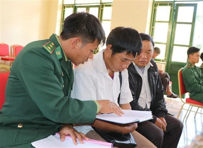 Chiến sĩ Đồn biên phòng Nậm Kè (Bộ đội Biên phòng tỉnh Điện Biên) trao đổi nội dung tuyên truyền, phổ biến pháp luật cho các trưởng bản. (Ảnh: TTXVN)