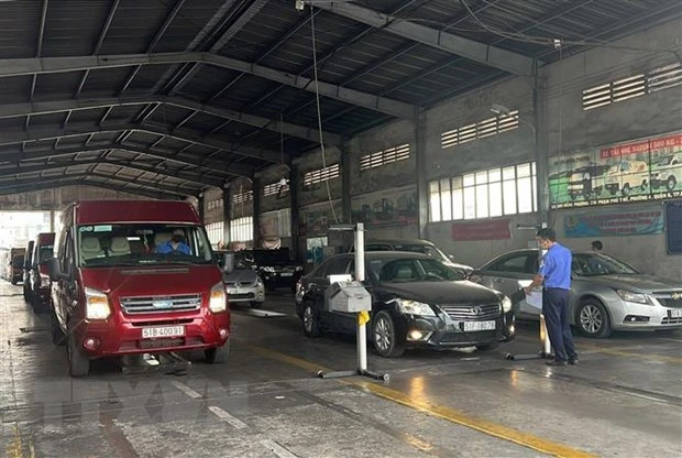 Đăng kiểm viên thực hiện nhiệm vụ tại Trung tâm Đăng kiểm xe cơ giới 50-02S. (Ảnh: TTXVN)
