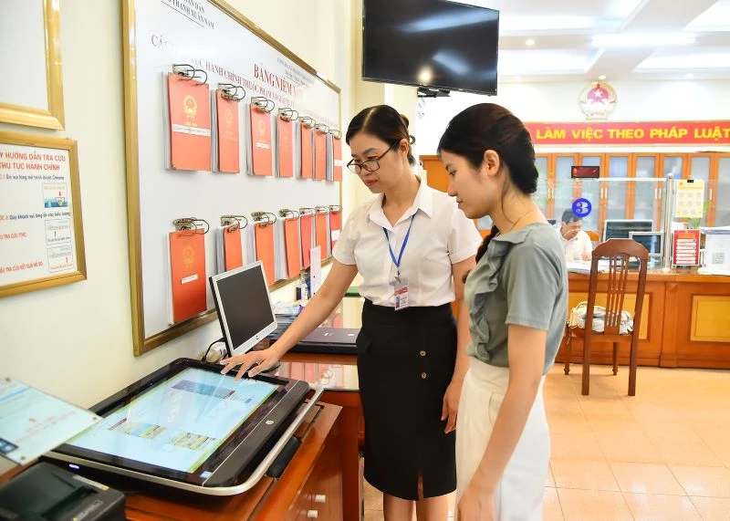 Cán bộ Ủy ban nhân dân phường Thanh Xuân Nam (quận Thanh Xuân, Hà Nội) hướng dẫn người dân thực hiện thủ tục hành chính trên môi trường mạng. Ảnh: Thuỷ Nguyên.