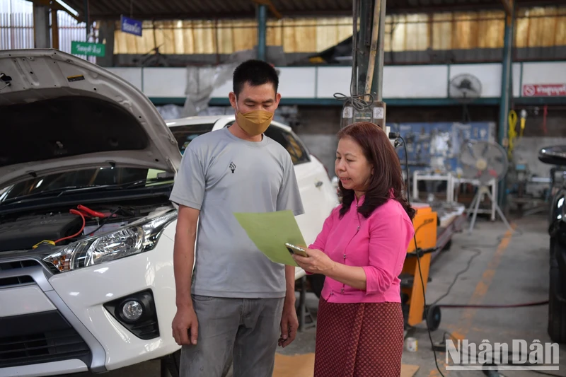 Chị Nit đang chỉ đạo nhân viên trong xưởng sửa xe của mình.
