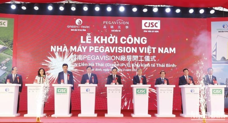 Các đại biểu thực hiện nghi thức bấm nút khởi công nhà máy sản xuất kính áp tròng tại khu công nghiệp Liên Hà Thái (tỉnh Thái Bình).