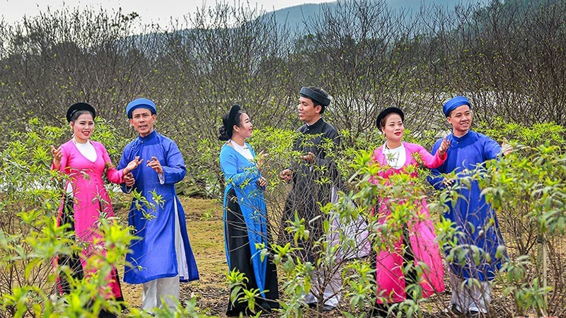 Các thành viên CLB dân ca ví, giặm xã Xuân Giang (Nghi Xuân) biểu diễn trong không gian vườn đào tại xã Cổ Đạm