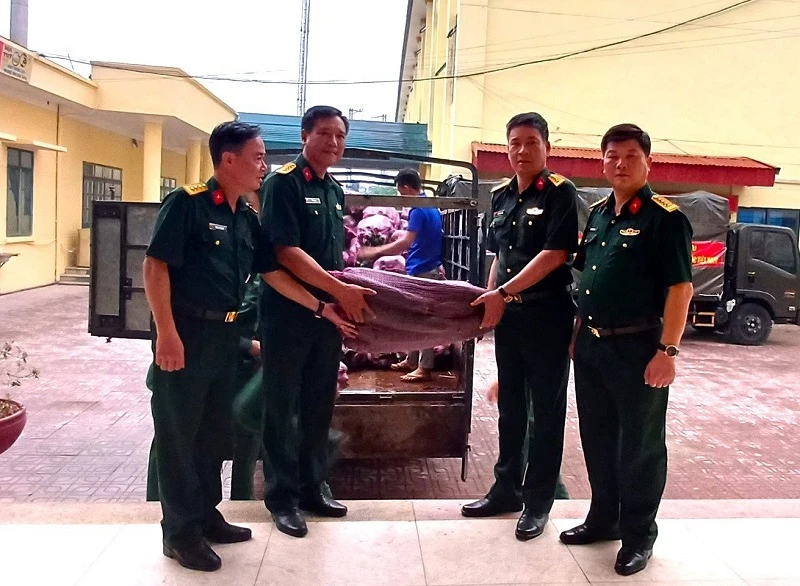 Đại diện cán bộ Ban Chỉ huy quân sự huyện Nậm Pồ trao bí xanh để các bộ phận chế biến phục vụ lực lượng diễu binh, diễu hành.
