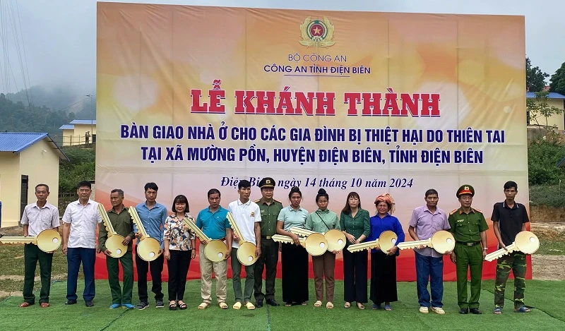 Đại tá Lù Minh Phương, Phó Giám đốc Công an tỉnh Điện Biên cùng các đồng chí lãnh đạo Huyện ủy, Ủy ban nhân dân huyện Điện Biên trao chìa khóa nhà đến 10 gia đình ở bản Lĩnh, xã Mường Pồn.