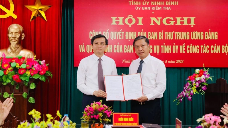 Đồng chí Đoàn Minh Huấn, Ủy viên Trung ương Đảng, Bí thư Tỉnh ủy Ninh Bình trao Quyết định của Ban Bí thư Trung ương Đảng cho đồng chí Đinh Việt Dũng. (Ảnh: ĐỨC LAM)