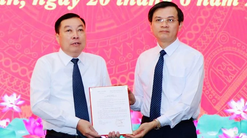 Đồng chí Đoàn Minh Huấn, Ủy viên Trung ương Đảng, Bí thư Tỉnh ủy Ninh Bình trao quyết định cho đồng chí Đinh Văn Tiên. (Ảnh: ĐỨC LAM)