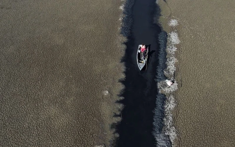 Thuyền đi qua một con nước hẹp ở hồ Titicaca, Bolivia, ngày 3/8. Ảnh: Reuters.
