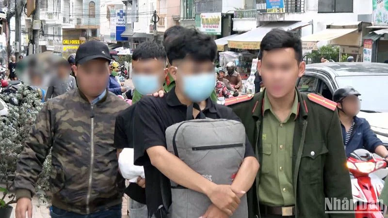 Hai đối tượng phát "danh thiếp lạ" nhằm chiếm đoạt tài sản trên không gian mạng bị lực lượng chức năng bắt quả tang. (Ảnh: Công an cung cấp)