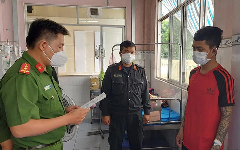 Công an tỉnh Đồng Tháp đọc lệnh bắt tạm giam đối tượng Phạm Hồng Qui. (Ảnh: Phước Thanh) 