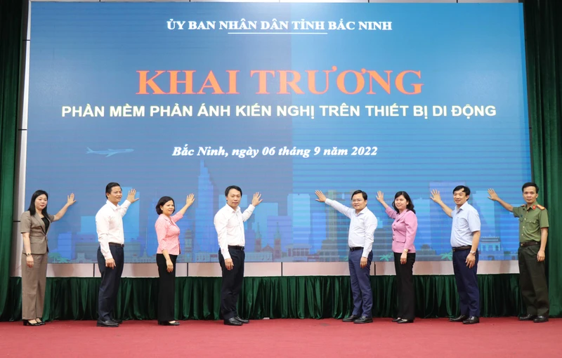 Các đại biểu thực hiện nghi thức Khai trương phần mềm phản ánh kiến nghị trên thiết bị di động.