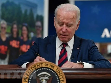 Tổng thống Mỹ Joe Biden ký một đạo luật tại Nhà Trắng. (Ảnh: AFP/TTXVN)