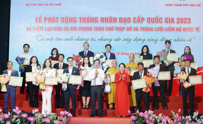 Chủ tịch nước Võ Văn Thưởng, Chủ tịch danh dự Hội Chữ thập Đỏ Việt Nam và bà Bùi Thị Hòa, Chủ tịch Hội Chữ thập Đỏ Việt Nam tặng hoa và trao bảng Ghi nhận tấm lòng vàng nhân đạo. (Ảnh: TTXVN) 