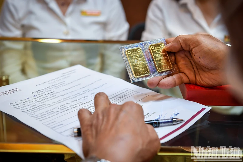 Người dân nhận vàng tại ngân hàng Agribank trong ngày đầu tiên ngân hàng này mở bán vàng đến người dân. (Ảnh: THÀNH ĐẠT)