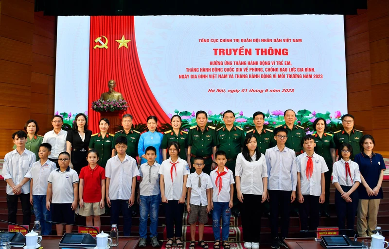 Các đại biểu chụp ảnh lưu niệm với trẻ em được nhận đỡ đầu. 