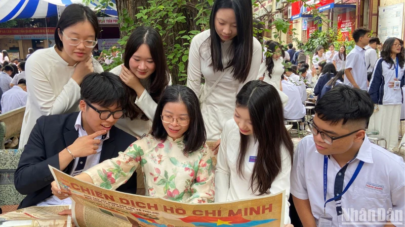 Cô và trò Trường trung học phổ thông Trần Phú xem phụ san đặc biệt về Chiến dịch Hồ Chí Minh của Báo Nhân Dân. 