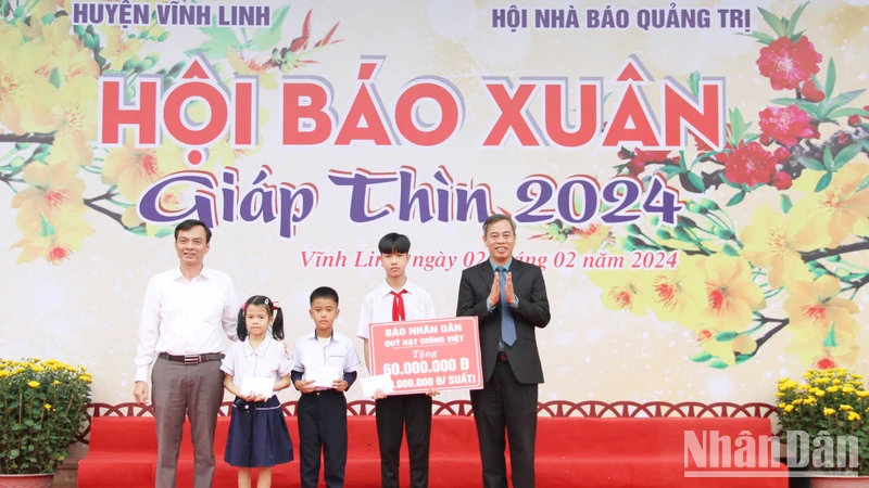 Phó Bí Thư Thường trực Tỉnh ủy, Chủ tịch Hội đồng nhân dân tỉnh Quảng Trị Nguyễn Đăng Quang cùng đại diện Báo Nhân Dân trao 3 suất quà cho học sinh ở xã Vĩnh Sơn, huyện Vĩnh Linh.