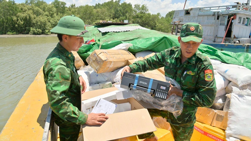 Cán bộ, chiến sĩ Đồn Biên phòng Lình Huỳnh kiểm tra hàng hóa dưới tàu. (Ảnh: TIẾN VINH)