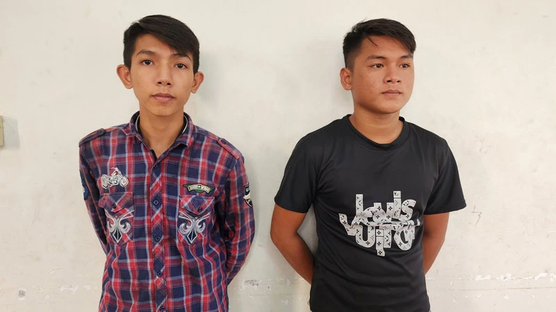 Công an đọc quyết định bắt tạm giam Nguyễn Minh Tâm (bên trái) và Trần Thanh Trọng. 