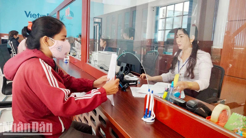 Công chức Trung tâm phục vụ hành chính công tỉnh Kiên Giang giải quyết thủ tục hành chính cho người dân. (Ảnh: QUỐC TRINH)
