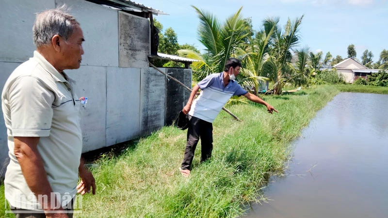 Ông Đặng Văn Đa (bên phải) chỉ nơi 2 cháu nội bị đuối nước tử vong.