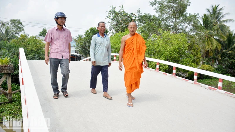 Ông Danh Hùng (giữa) đi trên cầu bê-tông do chính ông thiết kế và xây dựng.
