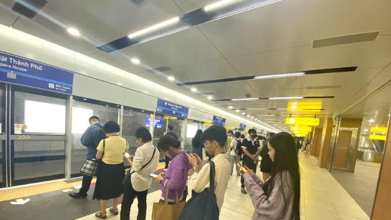 Hành khách xếp hàng chờ tàu Metro số 1 ở nhà ga. (Ảnh: QUÝ HIỀN)