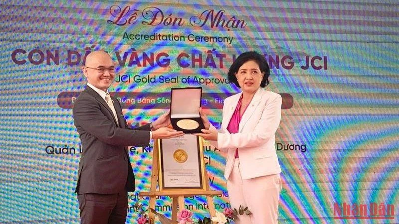 Đại diện tổ chức Thẩm định quốc tế Hoa Kỳ trao chứng nhận con dấu vàng cho Bệnh viện Quốc tế Phương Châu. (Ảnh: THANH TÂM)
