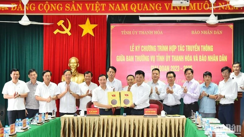 Phó Tổng Biên tập Báo Nhân Dân Quế Đình Nguyên và Phó Bí thư Thường trực Tỉnh ủy Thanh Hóa Lại Thế Nguyên trao nhau bản thỏa thuận hợp tác truyền thông giữa 2 cơ quan trước sự chứng kiến của lãnh đạo 2 đơn vị. (Ảnh: Thủy Nguyên)
