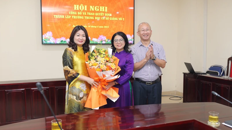 Hiệu trưởng Trường trung học cơ sở Giảng Võ 2 (ôm hoa) trong buổi nhận quyết định.