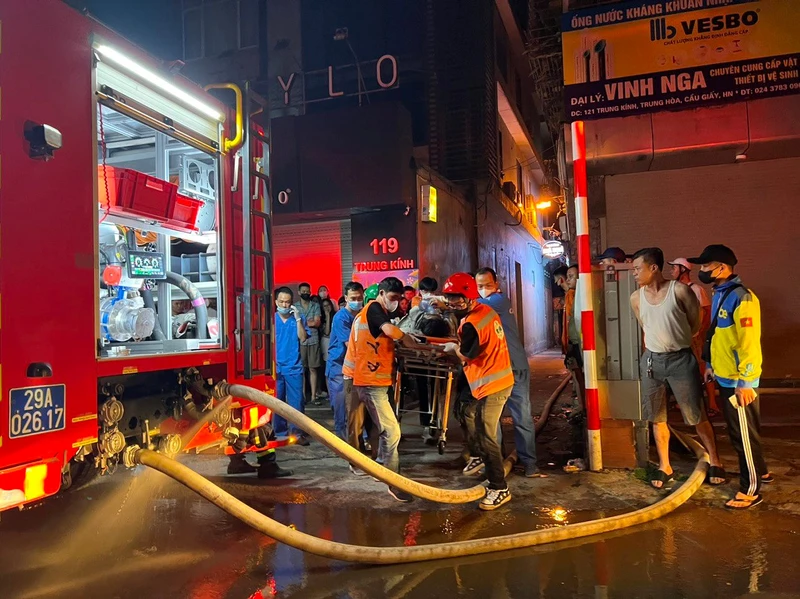 Lực lượng chức năng cứu hộ nạn nhân vụ cháy. (Ảnh: Khắc Hiếu)