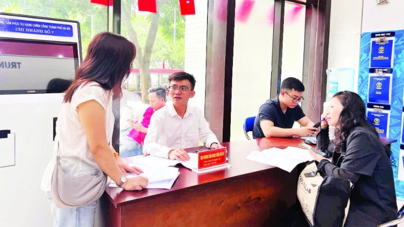 Cán bộ Trung tâm Phục vụ hành chính công-Chi nhánh số 7 hướng dẫn người dân hoàn thiện hồ sơ trước khi vào cửa tiếp nhận.