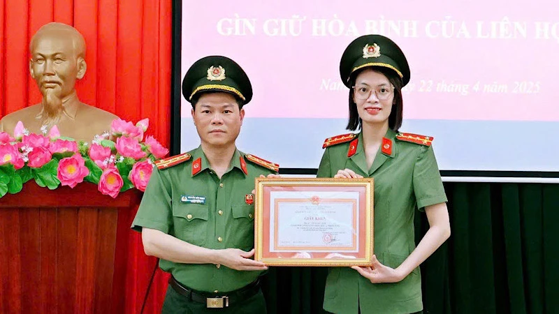 Đại tá Nguyễn Hữu Mạnh, Giám đốc Công an tỉnh Nam Định trao Giấy khen cho Đại úy Trần Mỹ Linh. (Ảnh: BÍCH MẬN)