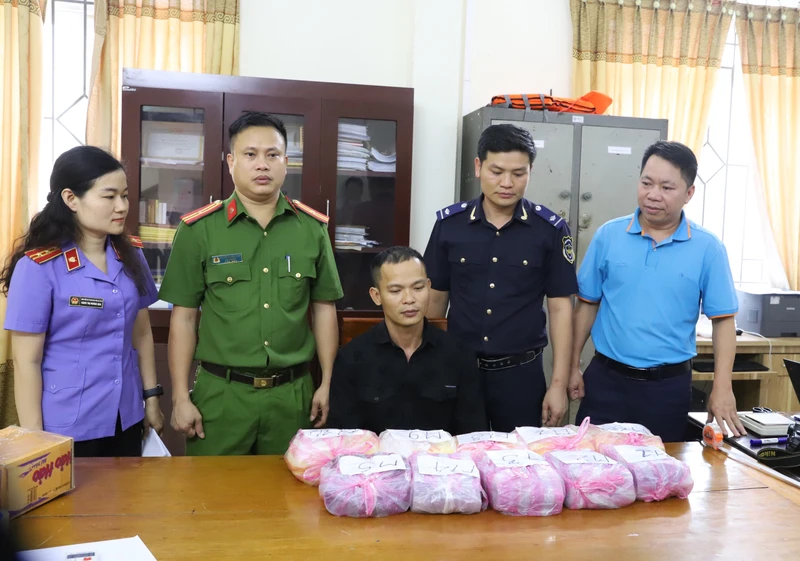 Đối tượng Nguyễn Thành Luân (người ngồi giữa) và tang vật bị thu giữ.