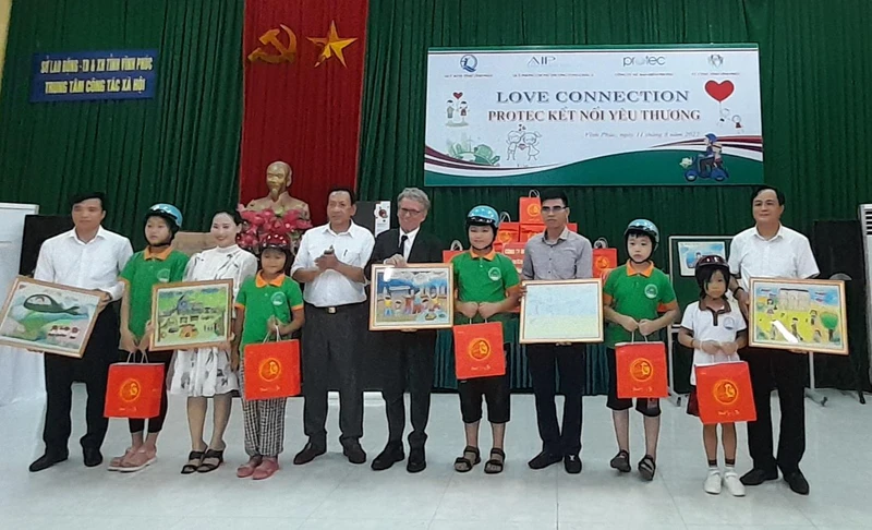 Các nhà tài trợ tặng quà, mũ bảo hiểm cho trẻ em đặc biệt khó khăn.