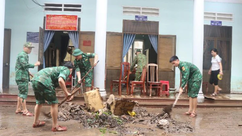 Cán bộ, chiến sĩ lực lượng vũ trang tỉnh Bình Định hộ trợ người dân, chính quyền khắc phục hậu quả mưa lũ tại phường Ghềnh Ráng.