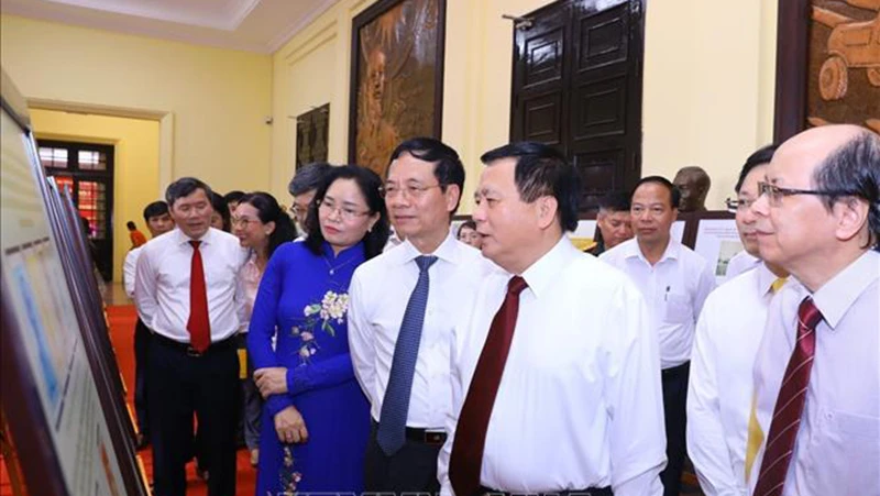 Đồng chí Nguyễn Xuân Thắng và các đại biểu tham quan triển lãm. (Ảnh: TTXVN)