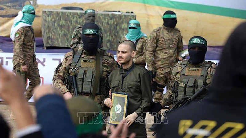 Lữ đoàn Al-Qassam, một cánh quân của Phong trào Hamas, trao trả con tin Israel cho Ủy ban Chữ thập đỏ quốc tế tại trại tị nạn Nuseirat ở miền trung Dải Gaza, ngày 22/2/2025. (Ảnh: THX/TTXVN)