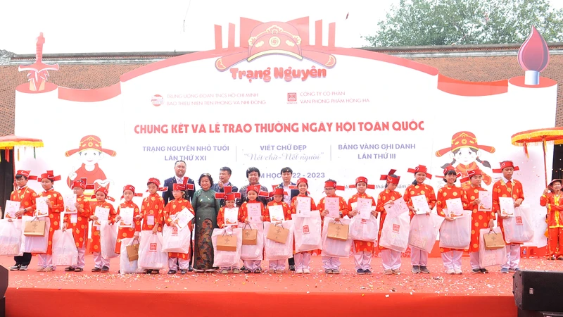 Các bạn Trạng nguyên toàn tài được nguyên Phó Chủ tịch nước Trương Mỹ Hoa và đại diện Ban tổ chức trao giấy khen và phần thưởng. (Ảnh: HUY HOÀNG)