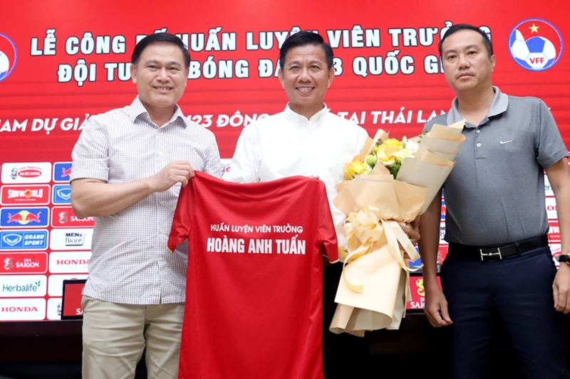 Phó Chủ tịch VFF Trần Anh Tú (trái) và Phó Chủ tịch VFF Nguyễn Xuân Vũ (phải) trao áo thi đấu đội tuyển U23 Việt Nam và tặng hoa chúc mừng HLV Hoàng Anh Tuấn đảm nhiệm cương vị mới. (Ảnh: VFF)