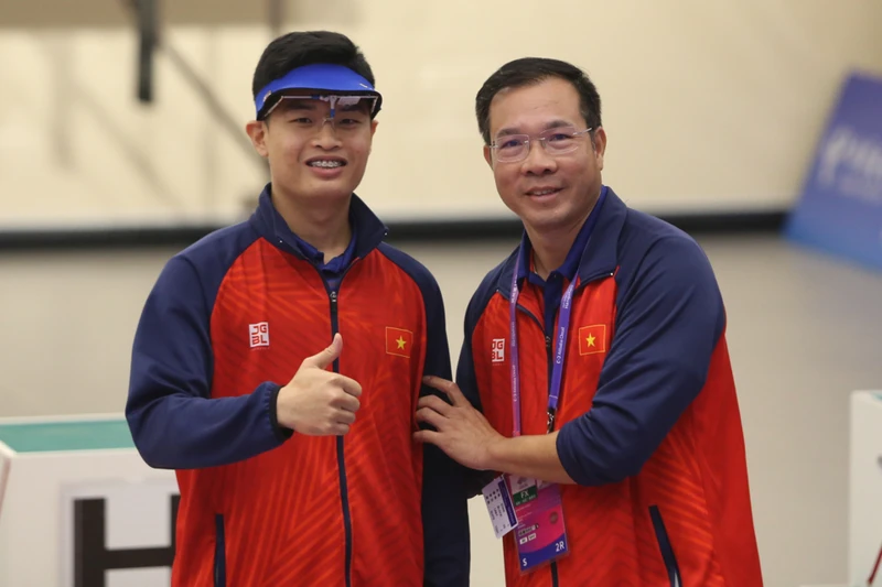 Xạ thủ Phạm Quang Huy và huấn luyện viên Hoàng Xuân Vinh. (Ảnh: Huy Đăng)