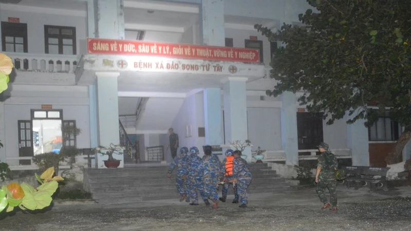 Đưa ngư dân bị bệnh vào Bệnh xá đảo Song Tử Tây điều trị. (Ảnh: CTV HQ) 