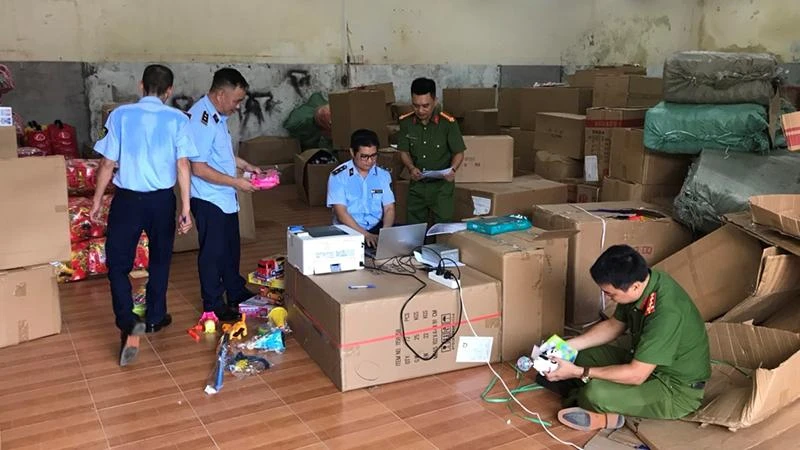 Lực lượng chức năng kiểm tra hàng hóa tại kho chứa hàng của hộ kinh doanh vi phạm.