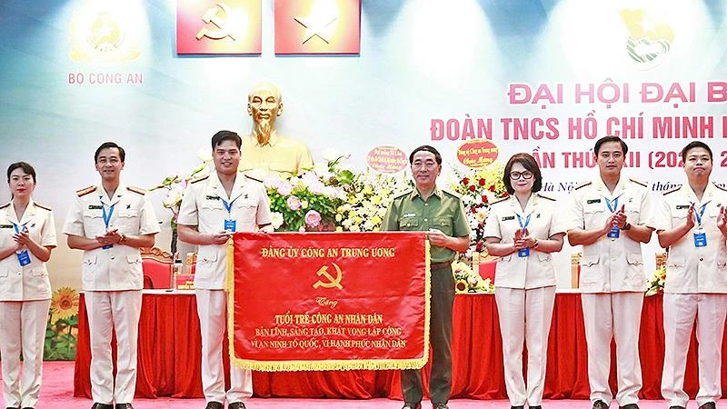 Thượng tướng Trần Quốc Tỏ (áo xanh) thay mặt Đảng ủy Công an nhân dân trao bức trướng “Bản lĩnh, sáng tạo, khát vọng lập công vì an ninh Tổ quốc, vì hạnh phúc nhân dân” tặng tuổi trẻ Công an nhân dân. 